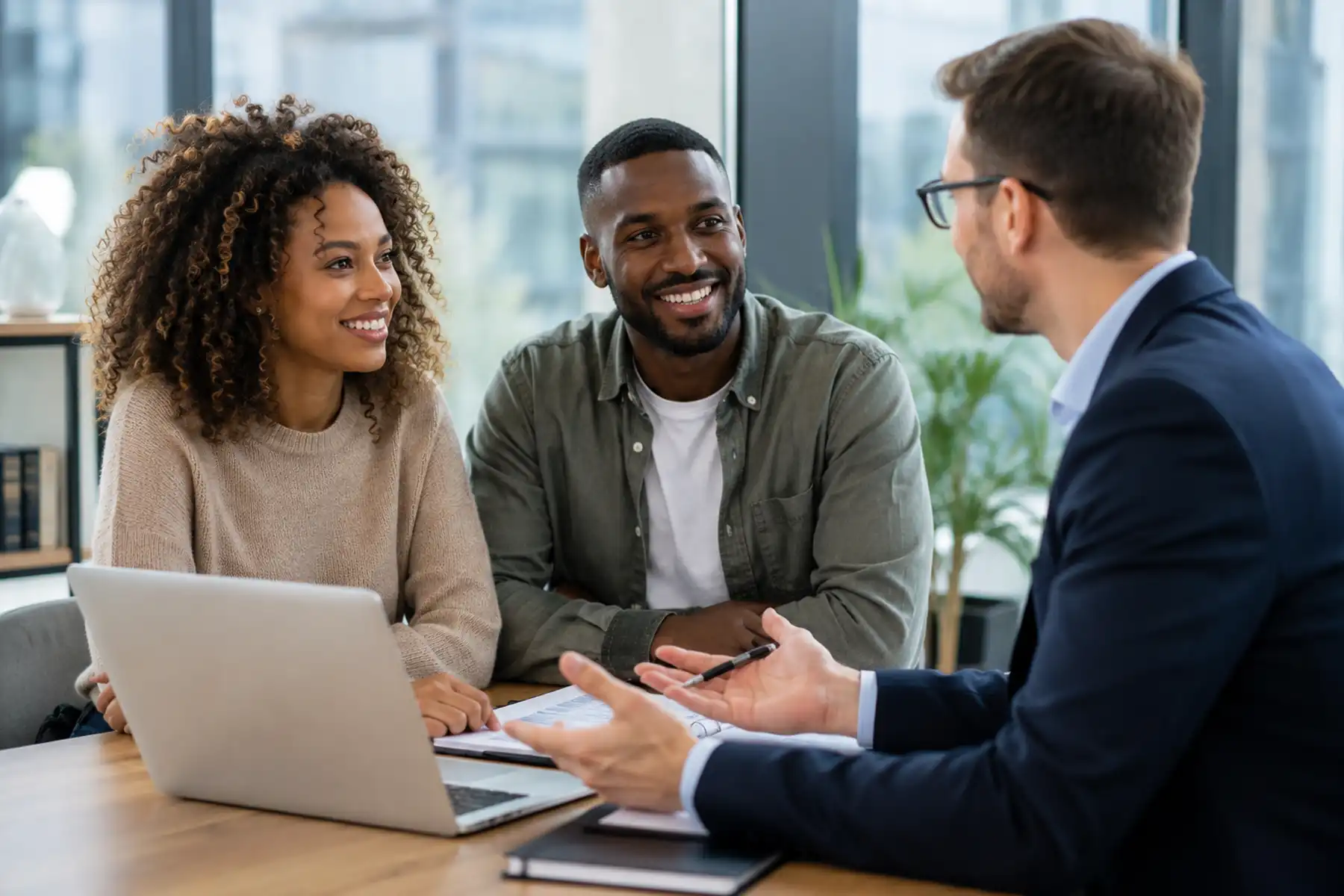 First-time buyer couple meeting with a mortgage adviser to discuss buying their first home.