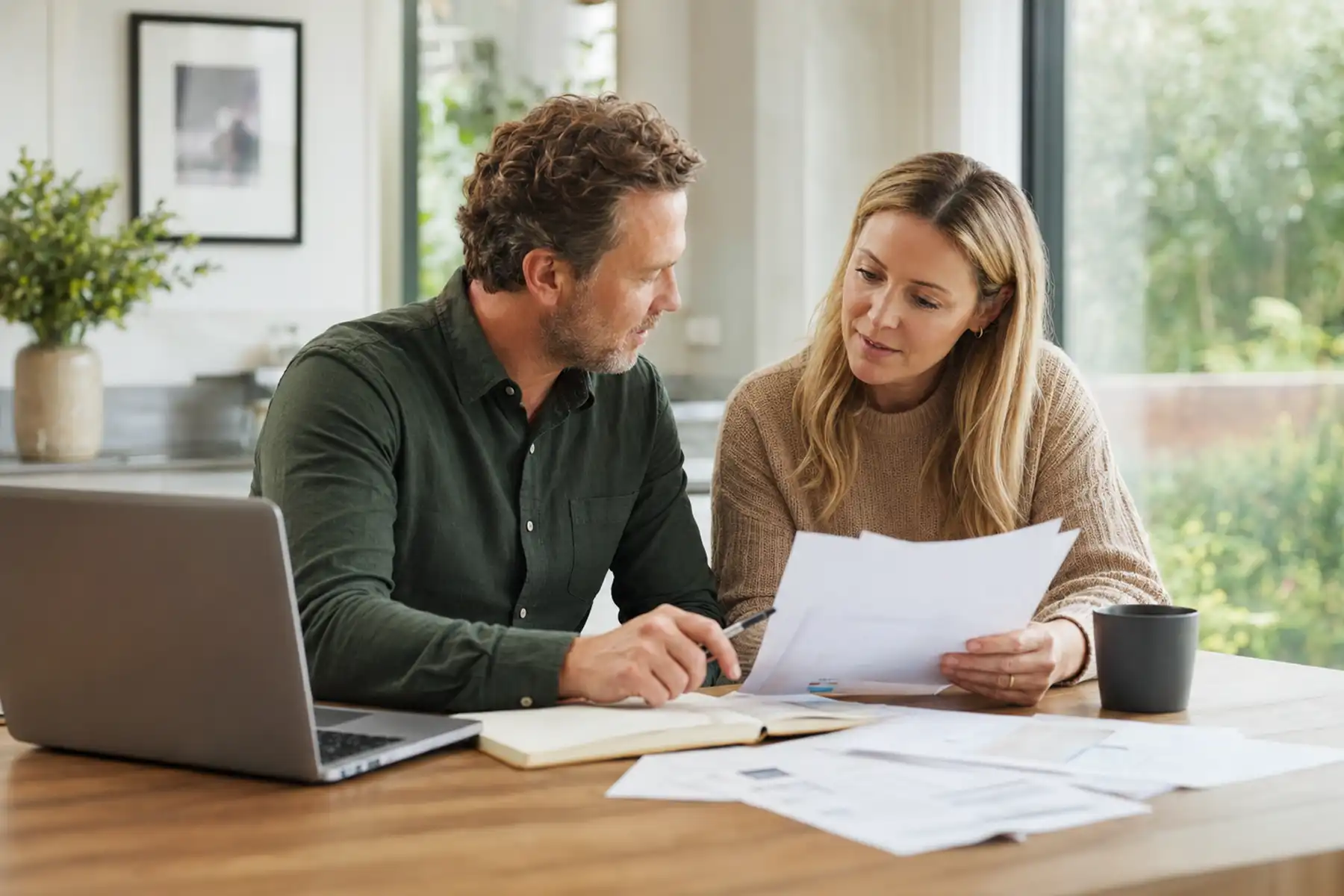 Couple reviewing household finances, employment benefits and protection documents together at home.