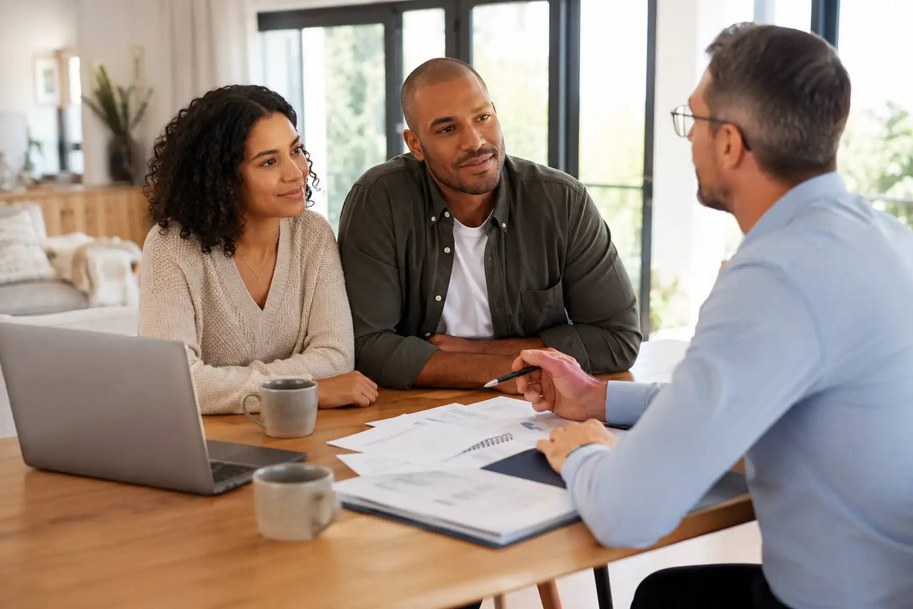 Couple discussing Mortgage Payment Protection Insurance options with an adviser in a contemporary UK home.