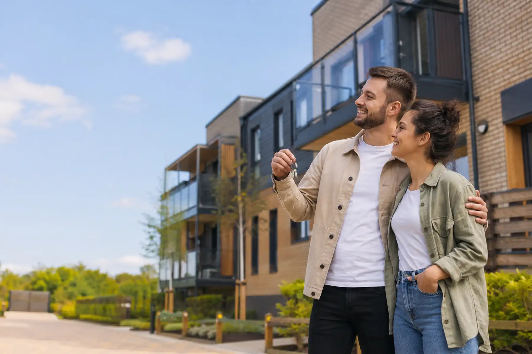 Couple outside a modern Shared Ownership style apartment development.